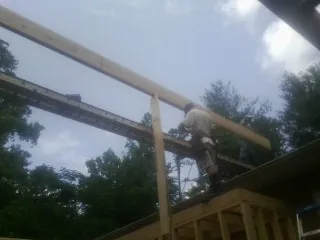 Carpenter setting a ridge beam over a new addition frame — Ice Dam Removal by Roofing Brothers in Ponsford
