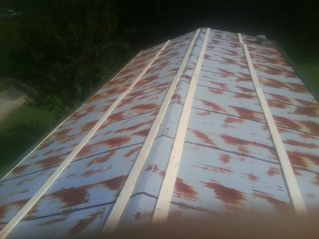 Rusted metal roof panels with new wood purlins before replacement — Storm Damage Roof Repair in Ponsford by Roofing Brothers